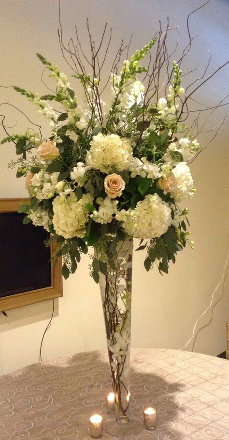 Tall pilsner arrangement with curly willow, hydrangea, roses, delphinium. Tall Flower Arrangements For Home, Hydrangea Centerpieces, Backyard Engagement, Backyard Engagement Parties, Tall Flower Arrangements, Tall Floral Arrangements, Tall Wedding Centerpieces, Hydrangea Centerpiece, Large Flower Arrangements