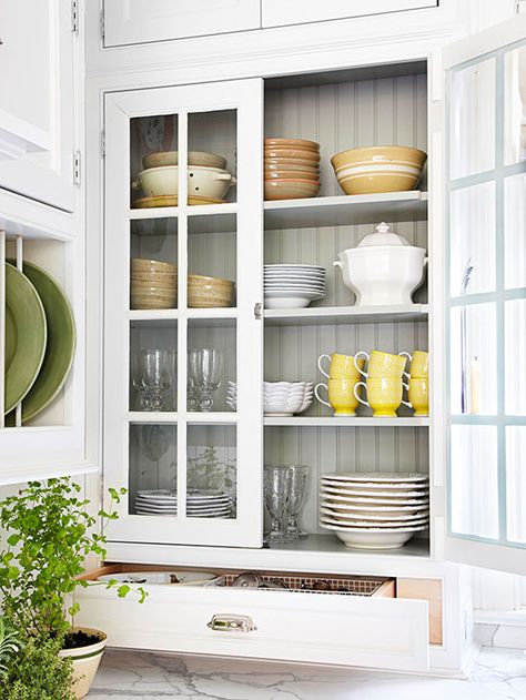 Display Collections Traditional glass-front cabinets flank the window, making the room look brighter. Beaded board, carried over from the backsplash, lines the cabinet interior. A collection of vintage dishware on display is both pretty and practical./ White Cottage Kitchens, White Cottage Kitchen, Grey Front Door, Cottage Kitchen Ideas, Old Kitchen Tables, Cabinet Interior, Trendy Farmhouse, Kitchen Traditional, Farmhouse Backsplash