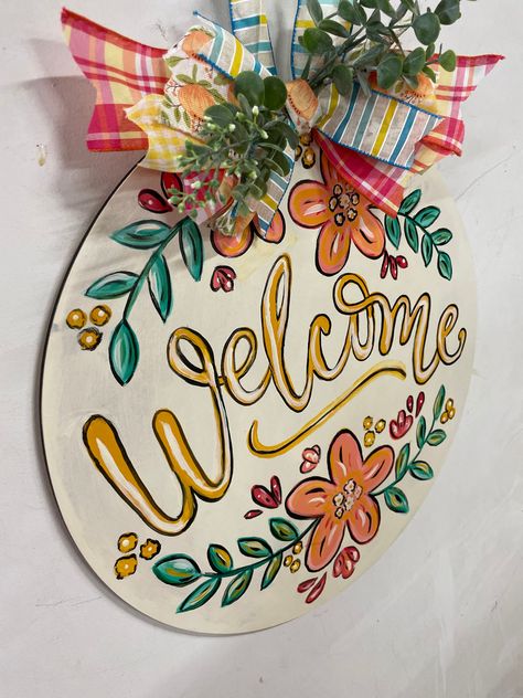 This floral wood Welcome door hanger provides a Welcoming entrance  and greeting to your home when added to your front door decor, porch decor, patio decor or interior space. A beautiful gift for that special person or relative or occasion. Circle Wooden Door Hangers, Circle Wood Door Sign, Hand Painted Door Signs, Round Painted Door Hanger, Fall Door Signs Diy, Circle Welcome Sign Front Door, Hand Painted Door Hangers, Welcome Sign Front Door Diy, Painted Door Signs