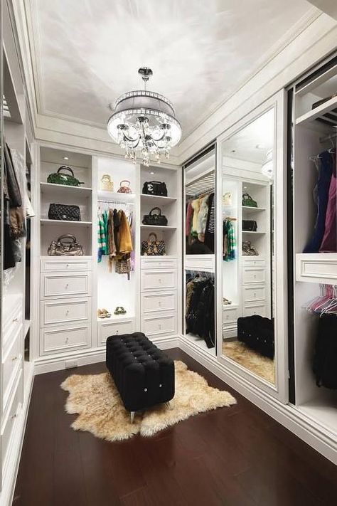 Chic walk in closet features a crystal droplets chandelier illuminating a black tufted bench on lucite legs atop a brown sheepskin pelt layered over wood floors. A Walk In Closet, Closet Vanity, Dressing Room Closet, Amazing Closets, Walking Closet, Dream Closet Design, Beautiful Closets, Walk In Closet Design, Closet Remodel