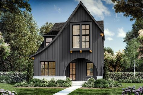 Dramatic swooping roof lines and an arched entryway catch the attention of those passing by this Contemporary Tudor home plan that is exclusive to Architectural Designs.French doors near the foyer open to a home office, across from a guest suite with a built-in bench tucked beneath the window.The open layout combines the great room, island kitchen, and dining area, and a 9' by 11'6" covered porch is ideal for grilling or dining outdoors.Three bedrooms and the laundry room reside upstairs, with t Modern Tudor Exterior, Contemporary Tudor, Modern English Tudor, Arched Entryway, Tudor House Plans, Tudor Home, Kitchen And Dining Area, Tudor Style Homes, Roof Lines