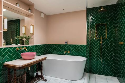 Bathrooms are secondary spaces, so they’re a great place to experiment with colour and pattern - and designers Barlow and Barlow are the masters at this. In this Notting Hill bathroom, our Crackle Bottle Green tiles are contrasted with pink walls, white marble floor tiles and gold brassware. As opposite colours in the colour spectrum, the pink and green complement each other while the herringbone layout and antique washbasin stand add a playful and unexpected element. Bright Wall Colors, Hotel Style Bathroom, White Marble Tile Floor, White Marble Floor, Eclectic Bathroom, Bright Walls, Double Vanity Bathroom, London Apartment, Design Apartment