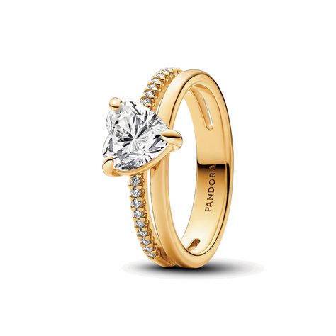 Love boldly with the Double Band Heart Ring. This 14k gold-plated ring features a unique design with two bands connected in several places: one plain polished band and one with pav� on the front half. At the centre is a sparkling heart-shaped cubic zirconia stone, creating an eye-catching statement. A modern yet classic piece that would make an elegant gift for the one who has your heart. Pandora Gold, Pandora Heart, Charms Pandora, Pandora Hearts, Gold Armband, Pandora Rings, Bracelet Cuir, Delicate Rings, Ring Size Guide