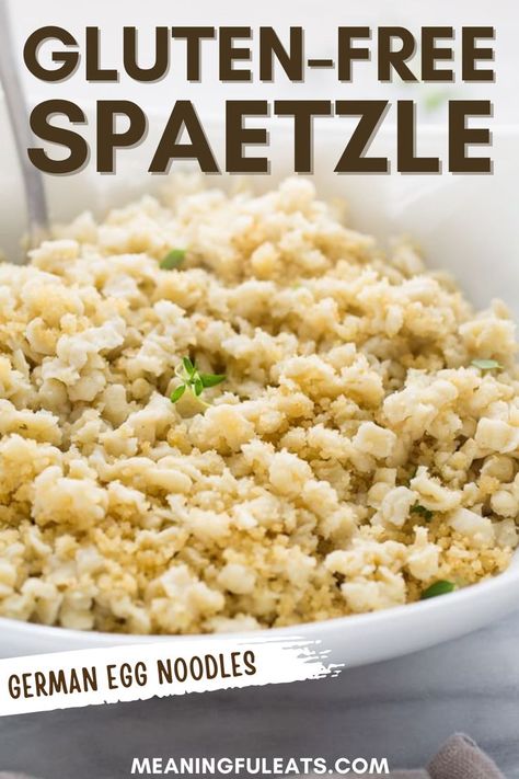 A bowl full of gluten-free spaetzle and topped with fresh green herbs.