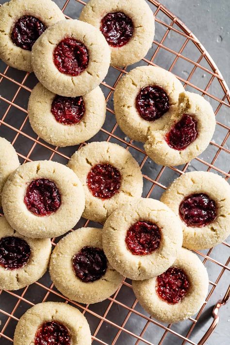 Jammy gluten-free thumbprint cookies made with almond flour. Soft chewy butter cookies paired with a moist jam-filled center, these are the perfect classic holiday cookie. #holiday #holidaycookie #glutenfree #glutenfreecookie #cookie #thumbprint #jam #raspberry #almondflour #recipe Gluten Free Christmas Baking, Gluten Free Thumbprint Cookies, Cookies Made With Almond Flour, Raspberry Thumbprint Cookies, Jam Thumbprint Cookies, Thumbprint Cookies Recipe, Christmas Baking Recipes, Jam Cookies, Gluten Free Christmas