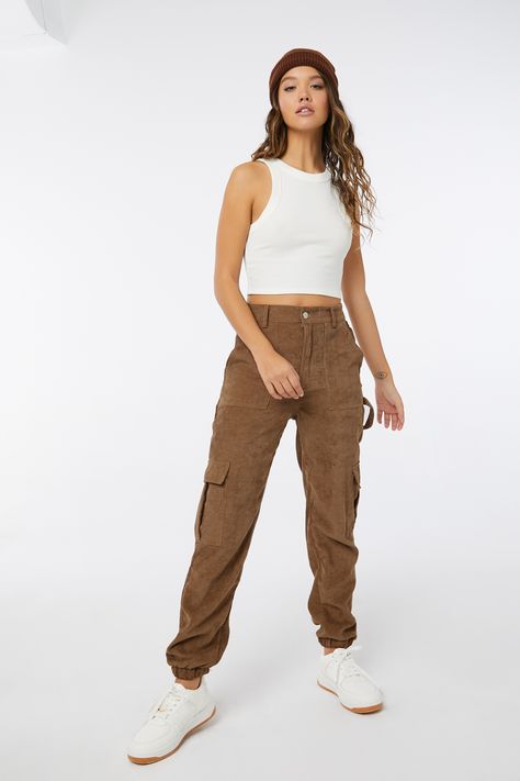 Corduroy carpenter pants. Ultra-high waist Button and fly closure Multiple pockets Elastic hem 98% polyester, 2% nylon Model is wearing size s | Ardene Corduroy Carpenter Joggers in Brown | Size Large | Polyester/Nylon Corduroy Carpenter Pants, Jogger Outfit, Brown Jeans, Carpenter Pants, Fitted Joggers, Cargo Joggers, Racerback Tank Top, Crop Tank, Flare Pants