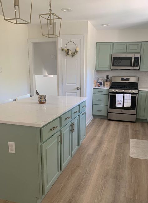 Cute, almost vintage look kitchen with white quartz, green painted cabinets, and island, wood look floor, Benjamin Moore Cloud White paint color on walls. Stainless steel appliances, gold hardware. #kyliem #greencabinets #paintedcabinets #whitequartz White Paint Colours, Benjamin Moore Cloud White, Kylie M Interiors, Painted Kitchen Cabinets Colors, Best White Paint, Green Kitchen Cabinets, Kitchen Wall Colors, White Appliances, Kitchen Paint Colors