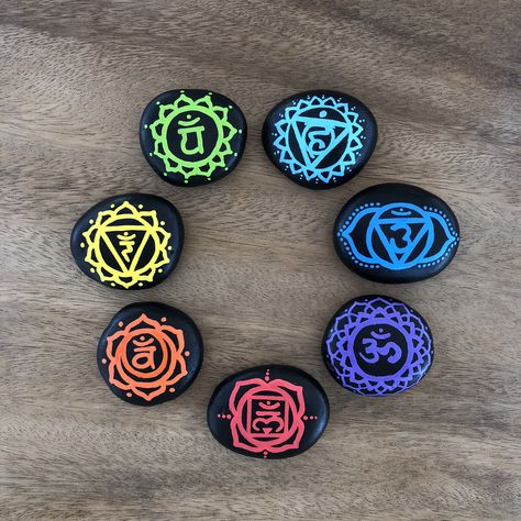 This is the unique set of seven hand painted chakra meditation stones with the traditional Sanskrit chakra symbols. The stones are painted with black acrylic paint and are maken 7 chakra symbols in rainbow colors on them. This adorable Chakra stone set comes with a small tulle bag for easy storage and travel for an energy boost or alignment when needed. Spiritual Rock Painting Ideas, 7 Chakra Symbols, Chakras Stones, Chakra Painting, Chakra Decor, Chakra Meanings, 7 Chakra Stones, Spiritual Paintings, Chakra Symbols