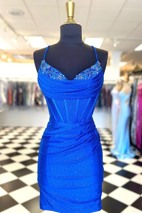 Introducing Cecily, a homecoming dress designed for the modern queen. Made from a shimmering jersey fabric, this sheath-style dress beautifully hugs your silhouette, revealing a fusion of confidence and grace. The dress boasts delicate spaghetti straps leading to a sultry V-neckline. The intricately designed drapes over the bust are complemented by the gentle pleats on the skirt. But the true star is the beading on the front neckline - a touch of sparkle to make sure you shine. Completed with a stylish lace-up back, Cecily offers both form and function. Whether it's making a statement entrance or sharing a dance, this dress ensures all eyes are on you. Details: Silhouette: Sheath Style Fabric: Shimmer Jersey Fabric Color: Royal Blue, Red, and Navy Blue Color Length: Short-Mini Length Neckl Tight Homecoming Dress, Hoco Inspo, Bodycon Dress Homecoming, Short Fitted Dress, Hoco Dress, Blue Corset, Red Corset, Dress Homecoming, Evening Dresses Cocktail