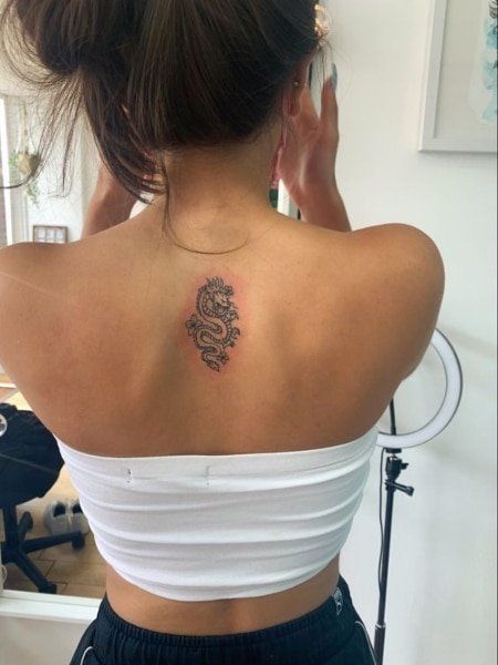 25 Coolest Back Tattoos for Women (2021)- The Trend Spotter Small Back Tattoo Ideas, Dragon Tattoo With Flowers, Back Tattoo Ideas, Tattoo With Flowers, Small Back Tattoos, Cool Back Tattoos, Upper Back Tattoos, Dragon Tattoo For Women, Muster Tattoos