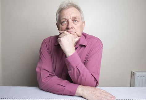 Older man sitting at a table with a ponderous expression as his chin rests on his hand. Hands On Table Pose, Chin Resting On Hand Pose, Successful Habits, Hands On Face, Portrait References, Older Man, Man Sitting, His Hands, The Fool