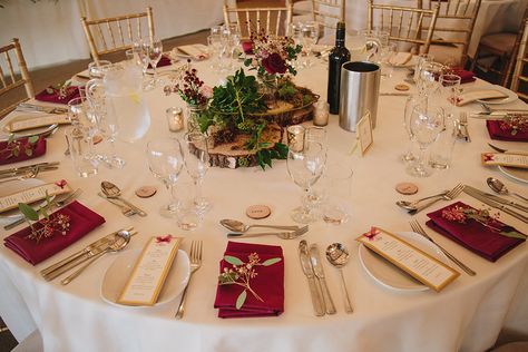 Round wedding tables were decorated with wood slices and pretty flowers with coordinating burgundy napkins at this rustic winter wedding at Sandhole Oak Barn Long Wedding Table Decorations, Burgundy Napkins, Winter Table Setting, Winter Wedding Decor, Round Wedding Tables, Gold Table Setting, Round Table Decor, Tropical Wedding Inspiration, Floral Crown Wedding