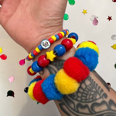 Clown pom pom beaded bracelet set clowncore accessories jewelry primary  Handmade clown bead bracelet set of 3 with chunky pom Pom bracelet and handmade fimo clay clown bead  ** CLOWN BEAD MAY CHANGE TO HAPPY FACE BEAD DEPENDING ON Availability! Perfect accessories to any fun outfit! Or cosplay  Tags;clown birthday party circus rave kidcore weird weirdcore kandi Clowncore Jewelry, Clowncore Accessories, Clowncore Kandi, Clown Kandi, Clowncore Fashion, Clown Stuff, Clown Accessories, Clown Core, Diy Kandi Bracelets