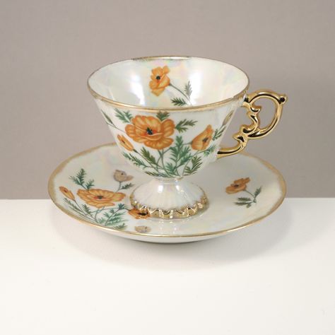 Beautiful footed teacup with orange flowers, gold trims and a mother of pearl finish, has that lovely oyster shell glaze  In good condition, no chip or cracks, and hardly any wear on the gold. The set is unmarked. Great for a cappuccino or a nice cup of tea!  Please note that vintage items have had a prior "life" and will have some normal wear and imperfections appropriate with the age. Any major or noticeable flaws will be mentioned in the listing.  I do ship internationally, but because of tax Teacup Aesthetic, Tea Princess, Fantasy Dagger, Unique Tea Cups, Vintage Tea Cups, Vintage Tea Cup, Vintage Teapot, Antique Tea Cups, Painted Cups