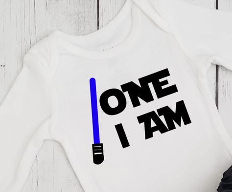 Boys 1st birthday shirt in Star Wars theme. One I am and light saber in your color choice. Custom designs available. One With The Force Birthday Party, The Force Is Strong With This One 1st Birthday, Star Wars 1st Birthday, Star Wars Theme Birthday, 1st Birthday Onesie, Birthday Onesie, Baby Birthday Themes, One Year Birthday, Birthday One