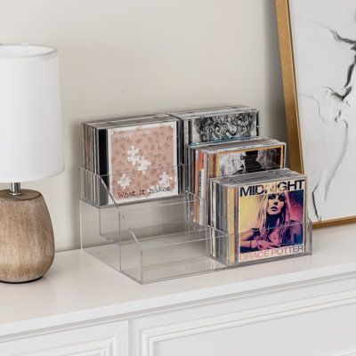 This trendy 3-tier clear acrylic CD storage rack is expertly perfect for showcasing your media collection. With 3 cascading tiers and six compartments, it can elegantly hold up to 36 compact discs, DVDs, or video game discs. Its sleekly designed structure complements any décor, and the 4mm thick acrylic ensures exceptional clarity for quick viewing. Ideally suited for tabletops, desktops, shelves, or inside cabinets, this compact media organizer keeps your collection neatly accessible. Especiall Cd Player Set Up, Cd Display Ideas, Cds Storage, Cd Storage Ideas, Cd Organizer, Cd Organization, Cd Display, Cd Holder, Cd Storage