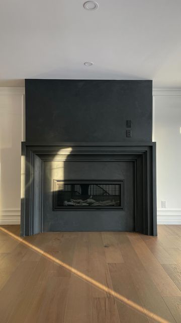 Black Wood Mantel Fireplace, Painted Stucco Fireplace, Bedroom Fireplace Remodel, Strike Fireplace, Academia Fireplace, Venitian Plaster Fireplace, Black Venetian Plaster, Black Fireplace Insert, Balls In Fireplace