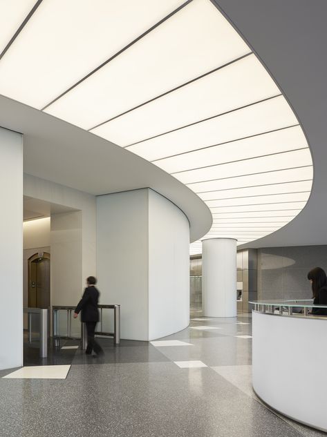 A substantial renovation of the iconic US Bank Tower in downtown Los Angeles by new owners OUE included this spectacular lobby upgrade. A luminous arc provides a focal point for the reception area beneath a large digital art display and the illumination delivered acts as a comfortable transition from daylight into the interior while providing wayfinding to the elevator area for visitors. ARCHITECT: Gensler / LIGHTING DESIGN: Lighting Design Alliance / Photo: ©Gensler/Ryan Gobuty #lighting #light Lobby Lighting Design, Luminous Ceiling, Us Bank Tower, Aesthetic Lighting, Lobby Lighting, Us Bank, Interior Design Layout, Design Strategies, Build Design