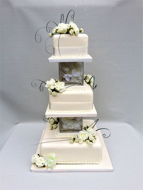 White iced tiers, stacked on glass cubes, filled with rose petals and fairy lights, with a flourish of bear grass and white roses. Wedding Cake Designs Simple, 3 Tier Wedding Cakes, Square Wedding Cakes, Designer Cakes, Floral Wedding Cake, Dream Wedding Cake, Floral Wedding Cakes, Fall Wedding Cakes, White Wedding Cakes