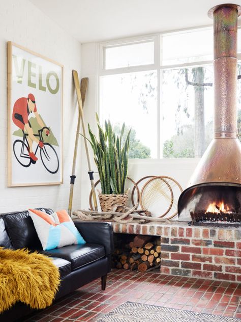 Couch by Bay Leather, shag throw rug from Freedom. Cushion from IKEA. Copper Canopy Fireplace was purchased on eBay. Victorian Timber Bike Wheels from Vintage Shabby Retro Moorrabin, Oars from Tyabb Antiques Centre, and Sanseveria from Din San Nursery. Photo – Eve Wilson. Production – Lucy Feagins / The Design Files. Midcentury Fireplaces, Midcentury Fireplace, Cozy Industrial Living Room, Copper Fireplace, Malm Fireplace, Fireplace Design Ideas, Hanging Fireplace, Recycled Brick, Freestanding Fireplace