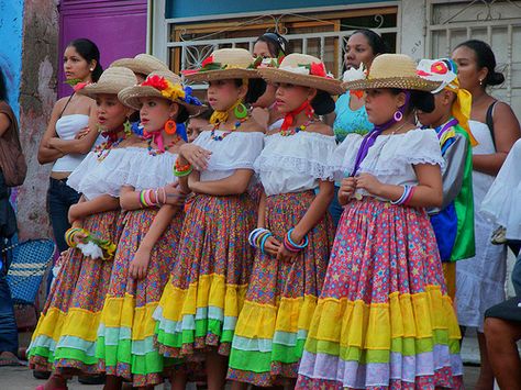 Most people in Venezuela wear the same things as we do here in the United States. But some women wear traditional long skirts with off the shoulder blouses, as shown above, and the men typically wear western clothes. Venezuelan Clothing, Dance Traditional, America Dress, Spanish Clothing, Zaragoza Spain, Catholic Saint, Mexico Culture, Traditional Dance, Folk Dresses