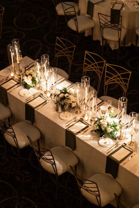 Elegant trios of floral arrangements and gold candlesticks with taper candles along the length of a long guest table. PC: Ann Coen https://www.anncoen.com/photography Tall Wedding Centerpieces Long Table, Gold Taper Candles Wedding, Tall Candle Centerpieces Wedding Long Table, Floral And Candle Table Decor, Taper Candle Centerpiece Wedding Long Table, Taper Candle Centerpiece Wedding Round Table, Candles Long Table Wedding, Long Wedding Tables With Candles, Wedding Long Table Centerpieces