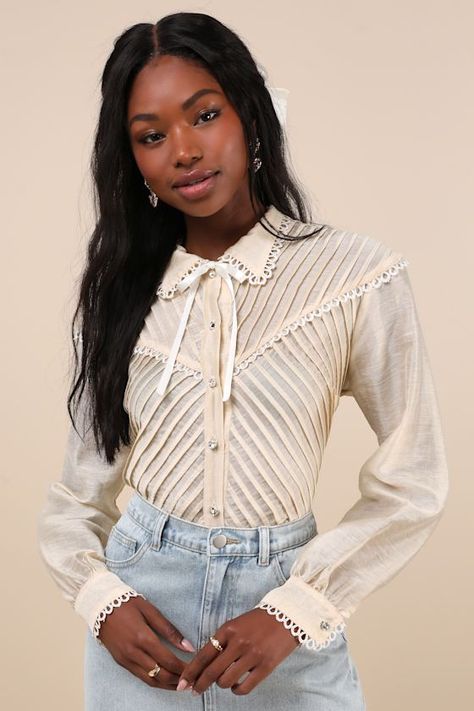 Timeless romance is the essence of the Sister Jane Pony Cream Sheer Pintuck Lace Long Sleeve Button-Up Top! Sheer, lightweight woven fabric shapes this vintage-inspired blouse that has long sleeves with rhinestone button cuffs and a collared neckline with an attached ribbon tie. Bodice boasts an angular design of pintuck pleats and a functional button placket with sparkly rhinestone buttons. Crochet lace trim throughout completes this sweetly chic look. Fit: This garment fits true to size. Bust: Lace Long Sleeve Top Outfit, Vintage Long Sleeve Top With Lace Collar, Cream Long Sleeve Top With Lace Collar, Feminine Lace Button-up Top, Lace Collar Shirt, Vintage Cream Button-up Blouse, Pintuck Pleats, White Sheer Button-up Blouse, Womens Lace Tops