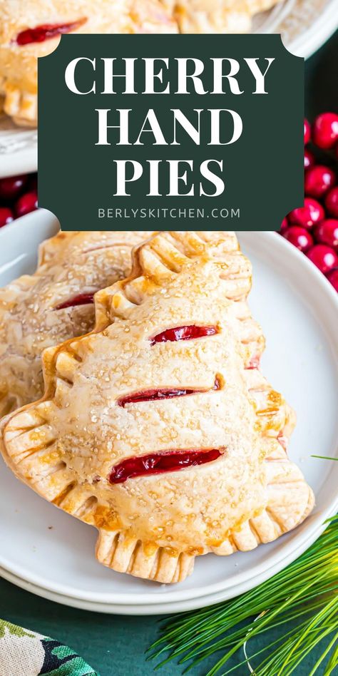 Two cherry hand pies on a white plate. Christmas Tree Cherry Hand Pies, Individual Cherry Pies, Baked Cherry Hand Pies, Hand Pies With Premade Pie Crust, Cherry Pie Individual, Fried Cherry Hand Pies, Cherry Hand Pies With Pie Crust, Mini Cherry Hand Pies, Cherry Sweets