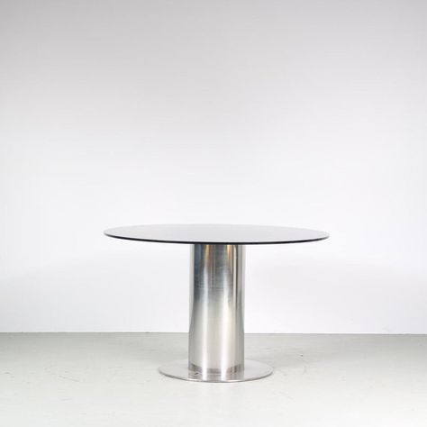 An eye-catching dining table, model “Cidonio”, designed by Antonia Astori, manufactured by Cidue in Italy around 1960.  This modern table is a true statement piece in the decor! It has a thick cylinder shaped, chrome plated metal base on a flat round foot. The smoked glass top works really well for this design, giving it a sense of luxury while keeping the structure visible from every angle. It’s combination of materials allows it to fit in many different decors, while s till drawing the attenti Round Metal Table, Steel Restaurant, Round Wood Table, Chrome Dining Table, Dining Table Price, Glass Round Dining Table, Glass Top Dining Table, Vintage Dining Table, Dining Design