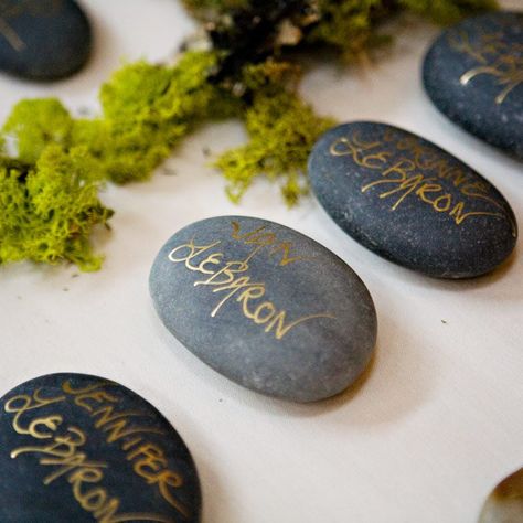 The couple played up their organic theme by using dark gray river rocks as escort cards. They wrote each guest's name on the stones with metallic gold ink. Front Table, Polished Rocks, Placement Cards, Diy Wedding Stationery, Table Assignments, Wishing Stones, Gold Writing, River Rocks, Seating Cards