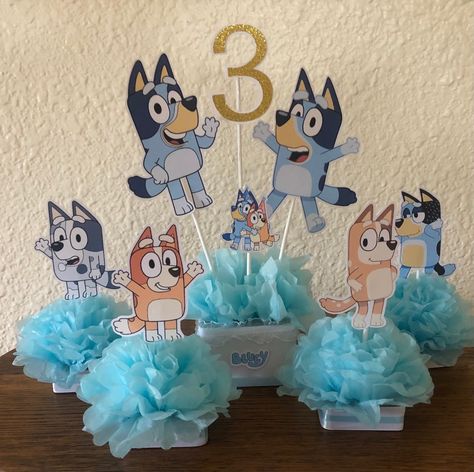 Bluey centerpiece is made with heavy card stock, satin ribbon and blue tissue flower  The main centerpiece is $20 and each character is $4. So what is in the picture is $36  you can purchase any or all parts When purchasing please put the AGE in the note section  It is so cute and would make a great addition to any bluey oarty Bluey Table Decorations, Bluey Graduation, Bluey Birthday Centerpieces, Bluey Centerpiece, Bluey Centerpiece Ideas, Bluey Diy Party, Bluey Decorations, Bluey Birthday Party Decorations, Bluey Party Decorations