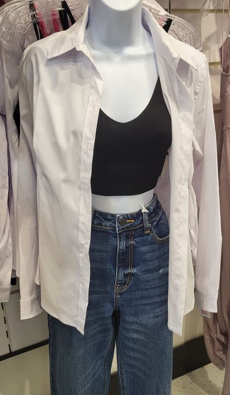 A mannequin with dark blue jeans, a black crop top tank top, and a white long-sleeved button up. White Long Sleeves Outfit Casual, White Long Sleeves Outfit, Black Sleeveless Top Outfit, Sleeveless Turtleneck Outfit, Button Shirt Outfit, Dark Blue Jeans Outfit, Sleeveless Top Outfit, White Top And Blue Jeans, Black Shirt Outfits