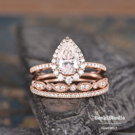 "3pcs Pear Cut Moissanite Engagement Ring Set Pear Shaped Wedding Ring Set Infinity Diamond Rose Gold Bridal Set Tear Drop Halo Ring Engagement ring: https://www.etsy.com/listing/1062234205 ITEM INFORMATION Metal Type - Solid 14k Rose Gold Band Width - (approx. 1.5mm) Center Stone: Moissanite, Pear Shaped * 6*9mm, about 1.6ct Color- D-E-F Clarity- VVS Side Stone - Natural Diamond or Colorless Moissanite Weight - 0.63ct Clarity -SI Color - H **Accent Stones: moissanite or diamonds can be selected. **Stone Replacement** Available with any other gemstones, please feel free to contact me for a quote. **Metal Type** Available in 14K or 18K yellow gold, white gold, and rose gold. Please select from the drop-down menu. **Production Time& Rush Order** Our standard production time is 3-4 weeks from Rose Gold Wedding Ring Sets Vintage, Teardrop Engagement Ring Rose Gold, Engagment Ring Sets, Wedding Bands For Pear Shaped Rings Halo, Rose Gold Engagement Ring Teardrop, Stacked Pear Engagement Ring, Rose Gold Pear Shaped Engagement Ring, Tear Drop Engagement Ring Set, Pear Diamond Ring Stack