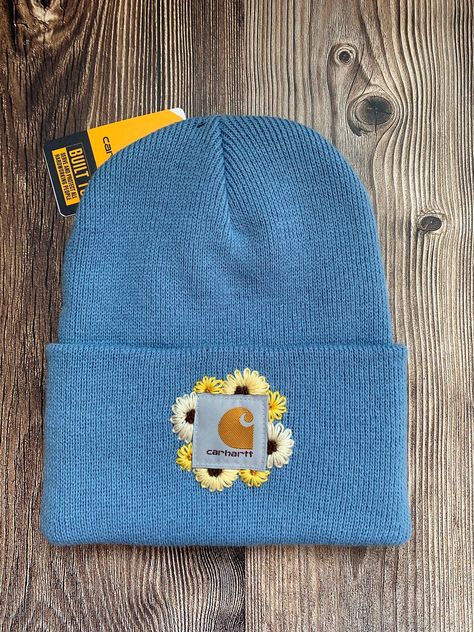 -Authentic Carhartt Knit Cuffed Beanie in the color Skystone. -Size Adult -100% Acrylic  Stand out in the crowd with this tried and true Carhartt beanie embellished with hand embroidered daisies! Hand Embroidery Beanie, Embroidery Carhartt Beanie, Carhartt Beanie Embroidery, Embroider Hats, Embroidered Carhartt Beanie, Embroidered Hats Ideas, Bonnet Carhartt, Beanie Embroidery, Embroidered Carhartt