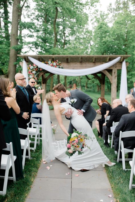 Groom dipping and kissing bride where column dress and cathedral veil. Wedding ceremony with white chairs. Color florals. Dip Kiss, Outdoor Spring Wedding, Elegant Spring Wedding, Wedding Venues Pennsylvania, Romantic Wedding Ceremony, Ceremony Photos, Wedding Kiss, Pennsylvania Wedding, Wedding Poses