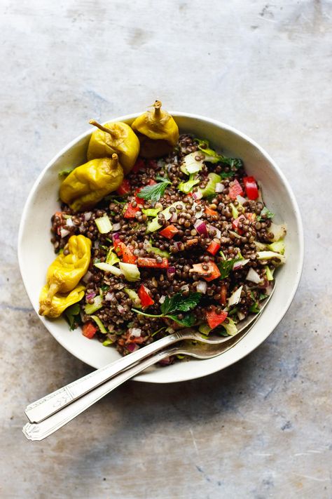 A crunchy lentil salad doused with a peppery, cumin pepperoncini dressing. A light lentil salad with a tangy, creamy vegan dressing. Salad With Pepperoncini, Crunch Salad, Parsley Leaves, Pepperoncini Peppers, Black Lentils, Vegan Dressing, Lemon Tahini Dressing, Photo Food, Lentil Salad