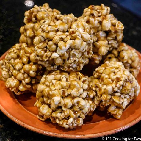 Learn how to make popcorn balls the traditional way with homemade caramel. Fun and easy to make, these delicious, sweet, and crunchy balls of popcorn make a perfect snack or gift for the holiday season. A new Halloween tradition the whole family will enjoy. Caramel Popcorn Balls Recipe, Pumpkin Popcorn Balls, Homemade Popcorn Balls, Soft Caramel Popcorn, Popcorn Balls Recipe Easy, Caramel Popcorn Balls, Popcorn Balls Recipe, Karo Syrup, Homemade Popcorn