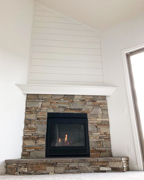 Heatilator direct vent gas fireplace with a real stone surround. The mantel is site built with shiplap above the mantel to the ceiling.  #shiplap #stonefireplace #gasfireplace #fireplacedecor #fireplace #homedecor Corner Fireplace With Shiplap Wall, Shiplap Above Stone Fireplace, Stone Fireplace With Shiplap Above, Stone Shiplap Fireplace, Corner Fireplace With Shiplap, Shiplap Over Stone Fireplace, Corner Fireplace Shiplap, Corner Stone Fireplace Ideas, Shiplap Stone Fireplace