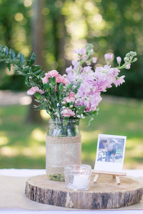 We covered our guests tables with white tablecloths and a burlap runner.  Centerpieces were log slices cut by a family friend , mason jars with burlap and ribbon hot-glued on, polaroid pictures on small wooden easels from Michaels, and a tea candle. Picture Centerpiece Ideas Birthday, Simple Table Centerpieces, Picture Centerpieces, Sisterhood Round, White Flower Centerpieces, Photo Centerpieces, Burlap Runner, Table Centerpiece Flower, Wooden Centerpieces