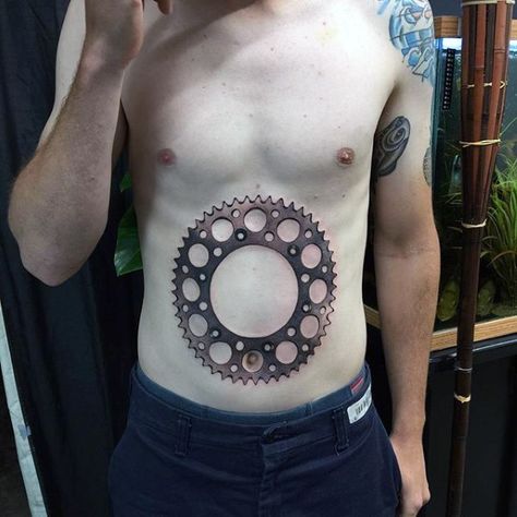 40 Sprocket Tattoo Designs For Men Spin Bike Tattoo, Sprocket Tattoo, Mens Motorbike Tattoo Ideas, Tattoo Ideas For Men Motorcycle, Tattoo Ideas For Men Bike, Bicycle Tattoos For Men, Cycling Tattoo, Cool Tattoos For Guys, Great Inventions