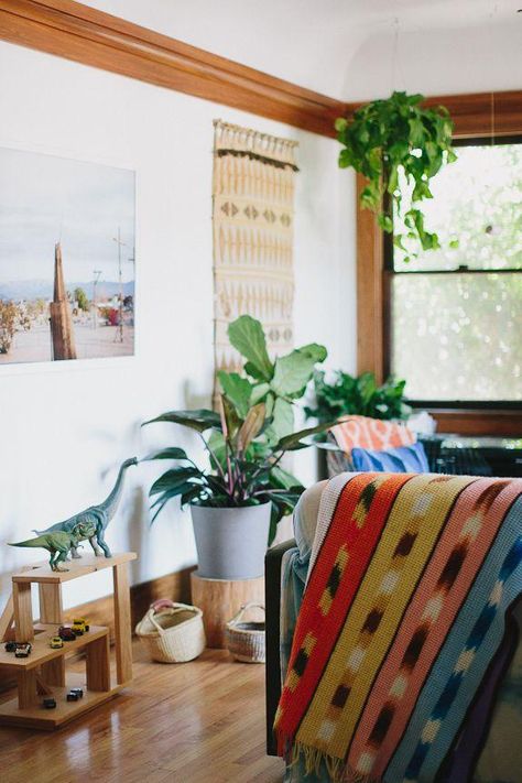 Bright, Bohemian Home on A Cup of Jo -- Love this eclectic and organic mix of styles with a modern take and colorful, Southwestern flair. Everything from the woven wall hanging to the colorful textiles to the dinosaur toy statues to the plethora of potted indoor plants is giving me great inspiration and ideas on how to style a bohemian, organic and family-friendly living room! Bohemian Living Room Decor, Bohemian Living Rooms, Cup Of Jo, Colorful Textiles, Bohemian House, Bohemian Interior, Bohemian Living, Up House, Eclectic Design