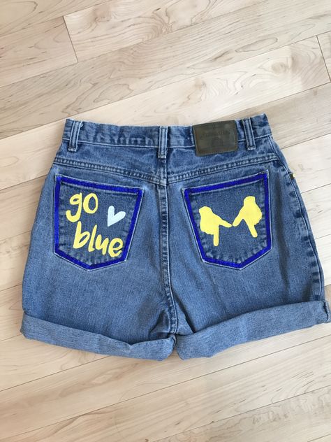 Hand painted items - see instagram if interested in purchase! denimbydesignn #DIY #umich #universityofmichigan #michigan #maize #blue #harbaugh #shorts #cutoffs #painted #denim #jean #jeanjacket #jeanshorts #jacket #shorts College Tailgate Outfit, Tailgate Clothes, Football Tailgate Outfit, College Gameday Outfits, College Tailgating, Painted Shorts, Diy Denim Jacket, Painted Clothes Diy, Diy Jeans