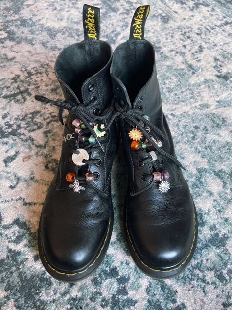 A pair of black doc martens boots with different beads and charms on the laces. Boots Diy, Grunge Boots, Moda Hippie, Mode Shoes, Beaded Shoes, Witchy Fashion, Looks Black, Moda Vintage, Shoe Charms