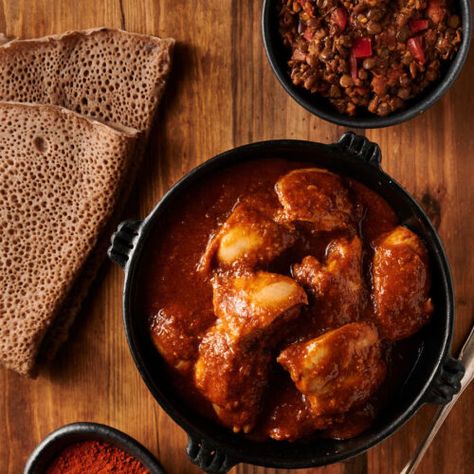 Door wat in a clay bowl with injera bread and lentils from above. Doro Wat Recipe, Ethiopian Chicken, Injera Bread, Doro Wat, Ethiopian Cuisine, Lentil Dishes, African Cooking, Slow Cooked Chicken, Ethiopian Food