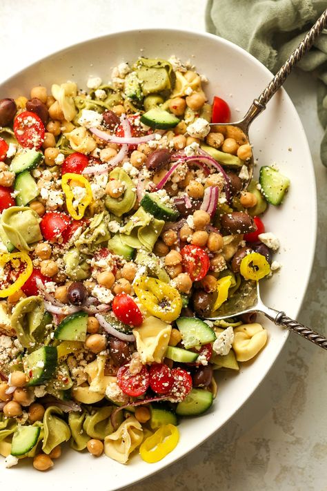 Our Greek Tortellini Pasta Salad combines fresh cheese-filled tortellini pasta, feta cheese, kalamata olives, garbanzo beans, and tons of veggies - all topped with a delicious Greek vinaigrette. This is a delicious summer salad that the whole family will love! Pasta Salad Vinaigrette, Greek Tortellini Pasta Salad, Greek Tortellini, Garbanzo Beans Salad, Tortellini Pasta Salad, Mediterranean Recipes Healthy, Greek Vinaigrette, Greek Cheese, Pasta Salad With Tortellini