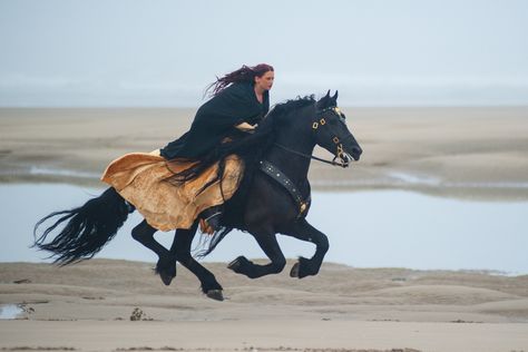 Young woman dressed in renaissance gallops her Black Friesian stallion along the tide and waves in Florence Oregon beaches, Equine Photo shoot. Women On Horseback, Woman Riding Horse In Dress, Women On Horse, Woman On A Horse, Horse And Woman, Woman On Horseback, Woman On Horse, Woman And Horse, Horse Woman