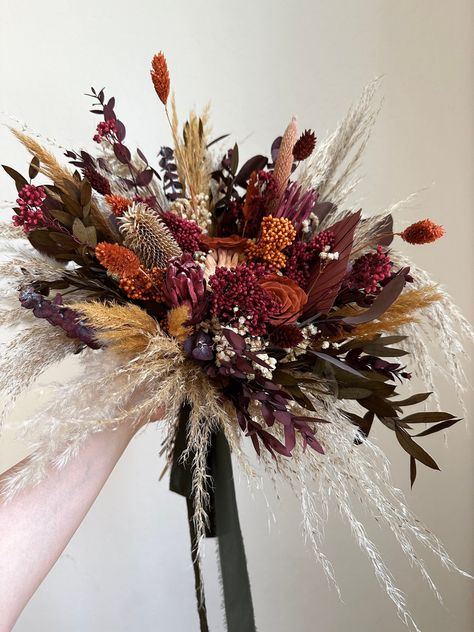 Dried everlasting boho bouquet including pampas grass, preserved roses, palms and bunny tail grass. This dried flower arrangement is made of a color combination of rust, terracotta, burgundy, pink, olive and orange, perfect for fall weddings.  SIZING INFORMATION 📏 > Large Bridal Bouquet is approximately 18"x16" > Small Bridesmaids Bouquet is approximately 10"x10" > Pinned Boutonniere is approximately 3.5"x3.5" (height x width).  > Pocket Boutonniere card is approximately 5"x3" (height x width). Dried Fall Arrangements, Teddy Bear Sunflower Bouquet, Fall Dried Flower Bouquet, Bright Fall Wedding Colors, Flower Bouquet Fall Wedding, Fall Bouquet Wedding, Boho Bridesmaid Bouquet, Fall Wildflower Wedding, Boho Floral Arrangements