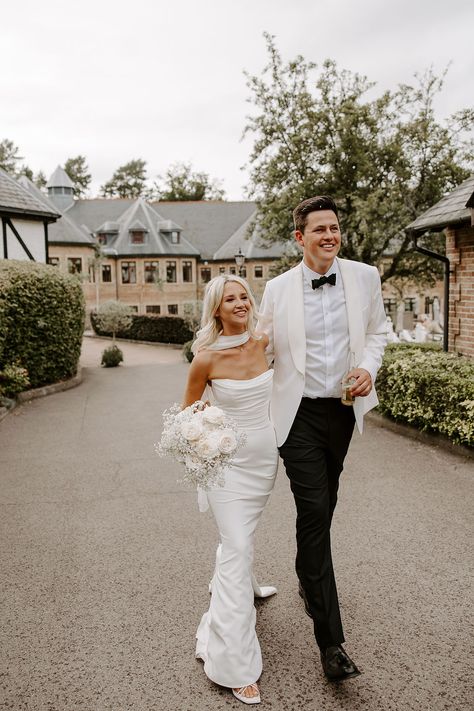 Uber-stylish newlyweds, with the bride dressed in a classic, fully fitted bridal gown and the groom in a black-tie tuxedo and white suit jacket. Chic, timeless and classically romantic, Pennyhill Park in Surrey was the perfect wedding venue to complement this couple's celebration. ⁠  Image Studio Rouge Ivory Dinner Jacket Wedding, White Black Tuxedo, White Tux Wedding, Black Tie Wedding Theme, Pennyhill Park, Dinner Jacket Wedding, European Wedding Venues, Groom In White, White Tuxedo Wedding