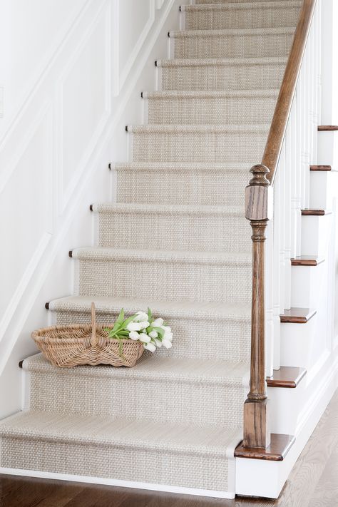 Get all the details for a DIY stair runner project with cost efficient, easy to clean stair runner rugs! Use an indoor outdoor runner for a look you're going to love. Find sources for modern stair runners and get a complete tutorial for how to accomplish this DIY in your own home - it's easier than you might think! As it turns out, the inexpensive solution for making over your old staircase may fit in your budget and your design dreams, too! You'll find pretty and practical ideas in this diy Diy Stair Rug Runner, Staircase Runner Rug, Neutral Runner Stairs, Carpeted Stairs To Wood Transition, White Oak Stairs With Runner, Carpet Stairs To Wood Transition, Coastal Stairwell, Stairs With Runners, Farmhouse Staircase Runner