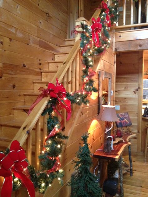 staircase Christmas garland at the cabin in Blairsville Ga Staircase Decoration Ideas, Christmas Garland Staircase, Staircase Decoration, Christmas Banister, Cabin Christmas Decor, Log Cabin Christmas, Christmas Stairs, Christmas Cabin, Christmas Staircase